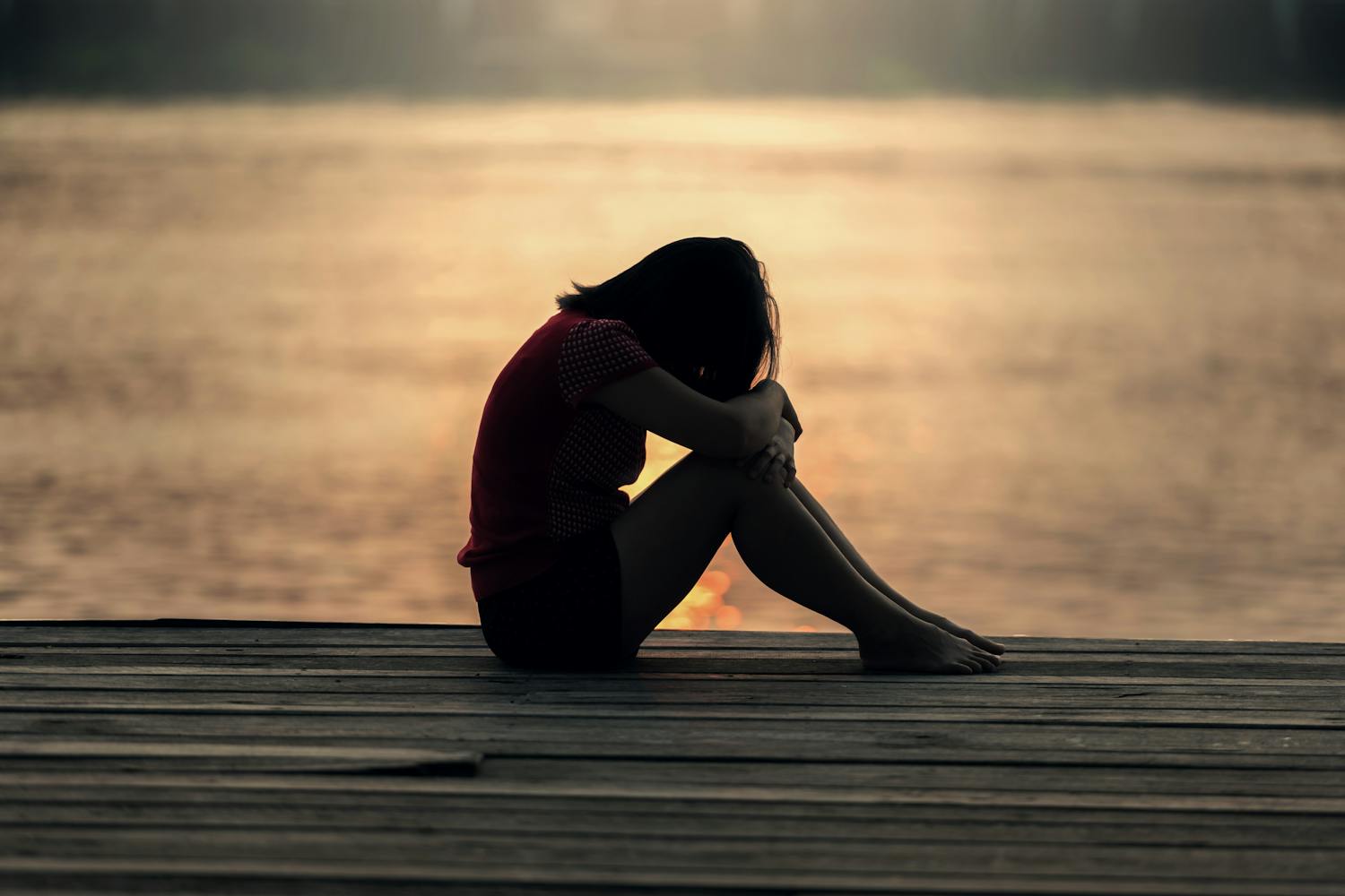 Person grieving by the water — bereavement counselling in Dublin.